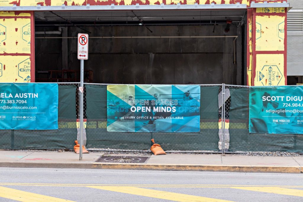 banner that reads open spaces open minds on fence