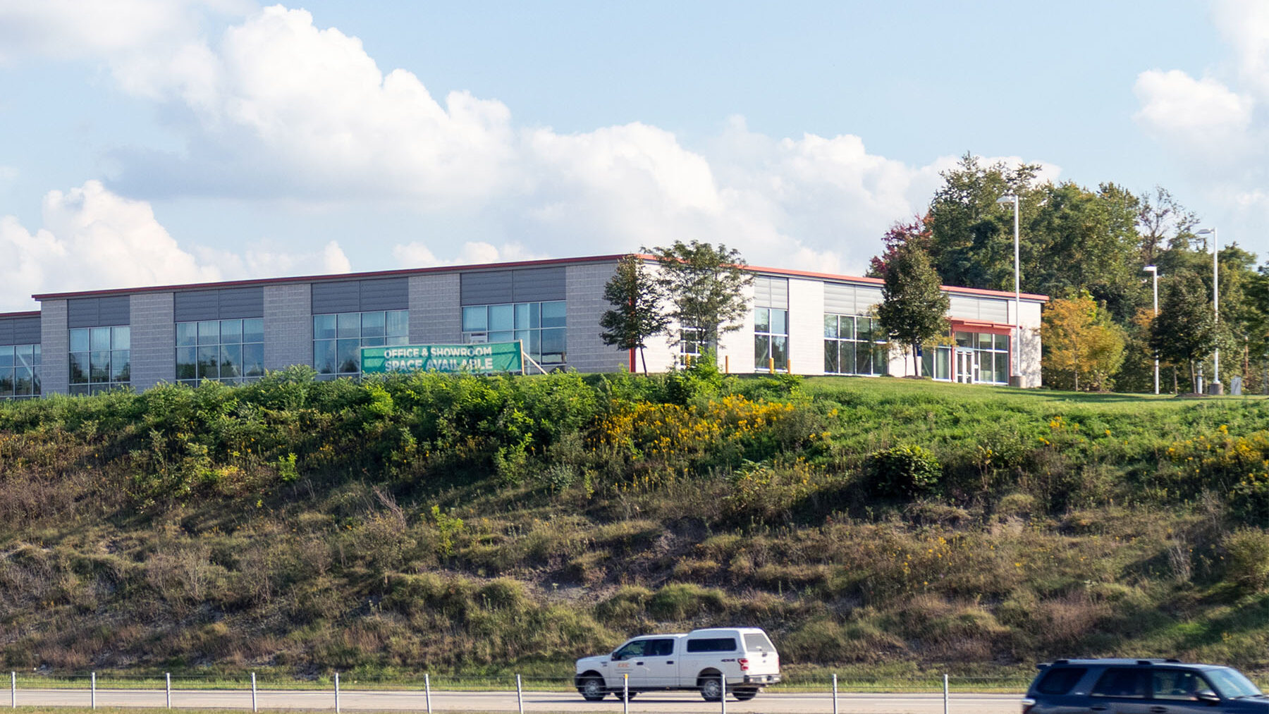 Cars Driving on Highway in Front of a Building