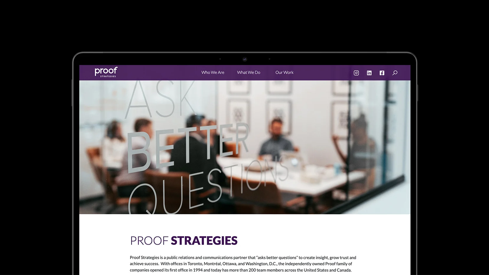 A laptop screen displaying a website for "Proof Strategies" with a visible conference room in the background. The glass wall reads "ASK BETTER QUESTIONS." The website menu includes "Who We Are," "What We Do," and "Our Work.