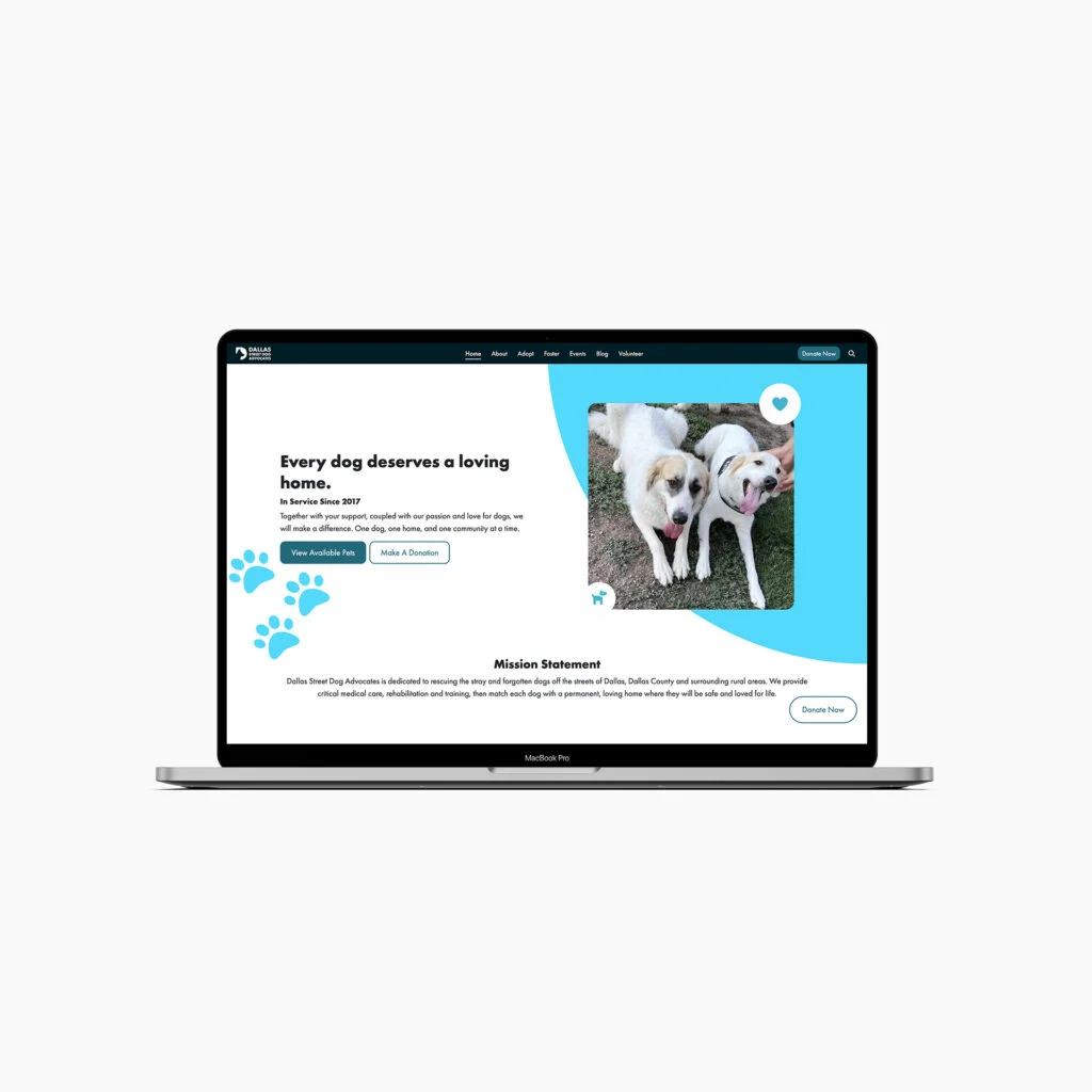 Laptop displaying a dog adoption website with images of two happy dogs, text on adoption, and a donation button.